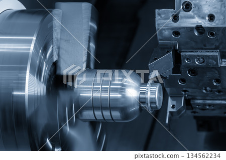 Close up scene the CNC lathe machine forming cutting the metal shaft part in the blue tone. Close up scene the CNC lathe machine forming cutting the metal shaft part in the blue tone. 134562234
