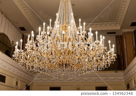 Grand Room With Sparkling Chandelier, Luxurious Hall Illuminated By Dazzling Crystal Fixture Grand Room With Sparkling Chandelier, Luxurious Hall Illuminated By Dazzling Crystal Fixture 134562348