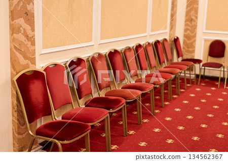 Elegant Ballroom With Red Seating, Charming Hall Featuring Plush Carpets And Golden Accents 134562367