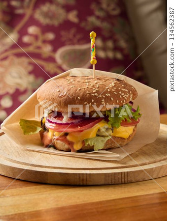 Grilled cheese burger with crisp vegetables, Delicious melted cheese burger with sesame bun and toppings Grilled cheese burger with crisp vegetables, Delicious melted cheese burger with sesame bun and toppings 134562387