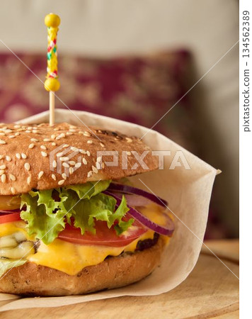 Quick snack packed in parchment, Convenient street food burger wrapped with parchment and ingredients Quick snack packed in parchment, Convenient street food burger wrapped with parchment and ingredients 134562389
