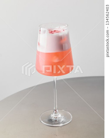 Stylish beverage featuring bubbles and berry garnish on sleek table 134562403