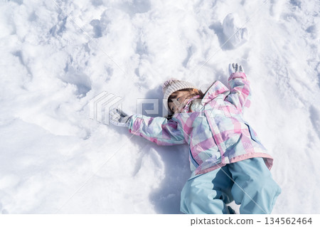 Girl lying down in the snow Girl lying down in the snow 134562464