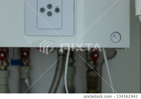 Water pressure meter on the panel of the heating gas boiler. Symbolic image of the heating season at home. Water pressure meter on the panel of the heating gas boiler. Symbolic image of the heating season at home. 134562942