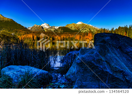 Majestic High Tatra mountains panorama reflected in lake during autumn 134564520
