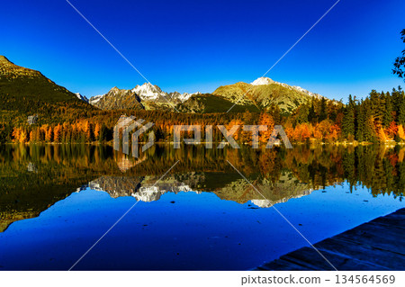 Majestic High Tatra mountains panorama reflected in lake during autumn 134564569