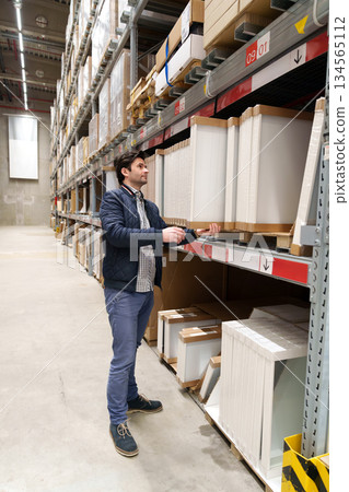 Man choosing furniture in warehouse store Man choosing furniture in warehouse store 134565112