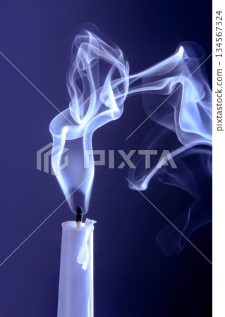 Smoke from an extinguished candle on a dark background. Smoke from an extinguished candle on a dark background. 134567324