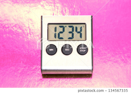 A sleek digital kitchen timer displays 12 34 on a bright yellow background. 134567335