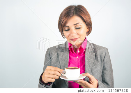 Business woman drinks coffee from a white cup close-up 134567828