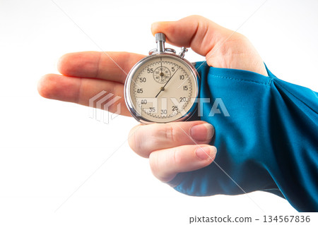 hand with a mechanical analog stopwatch on a white background hand with a mechanical analog stopwatch on a white background 134567836