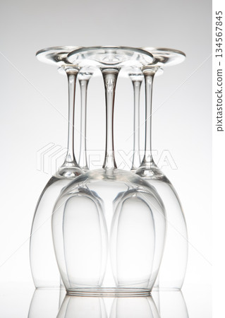A five empty wine glasses with distinct designs, their reflections creating a mirror effect  134567845