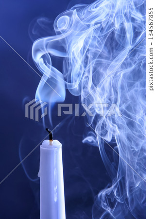 Smoke extinguished candle on a dark background. The concept of spirituality and the end of life. Smoke extinguished candle on a dark background. The concept of spirituality and the end of life. 134567855