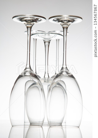 five empty wine glasses with distinct designs, their reflections creating a mirror effect 134567867