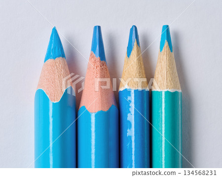 A row of blue wooden drawing pencils with sharp tips on a white background A row of blue wooden drawing pencils with sharp tips on a white background 134568231