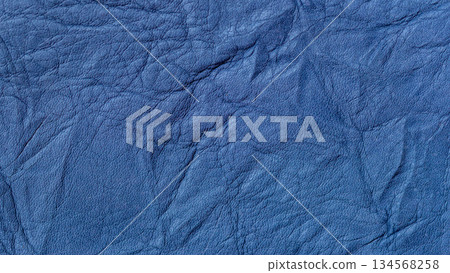 Close-up of wrinkled blue leather texture with natural grain and creases. Natural accessory background, fashion design, trendy color, copy space Close-up of wrinkled blue leather texture with natural grain and creases. Natural accessory background, fashion design, trendy color, copy space 134568258