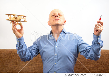Dream of flight. inventor concept. man with a bald head and a blue shirt  134568292