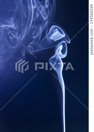 Smoke from an extinguished candle on a dark background 134568294