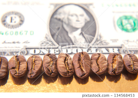 Macro shot of roasted coffee beans resting on a U.S. dollar bill Macro shot of roasted coffee beans resting on a U.S. dollar bill 134568453