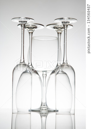Crystal wine glasses in various shapes stand tall, their reflections doubling on a sleek surface Crystal wine glasses in various shapes stand tall, their reflections doubling on a sleek surface 134568487