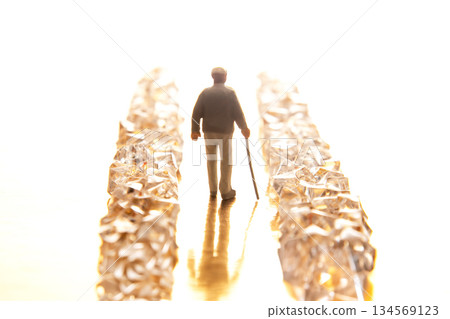 A tiny suited figure walks through a sparkling crystal pathway on a reflective golden base 134569123