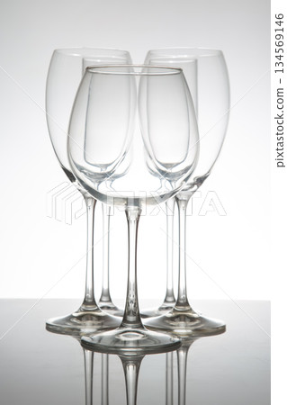 Elegant wine glasses with long stems and clear bowls, arranged in a line Elegant wine glasses with long stems and clear bowls, arranged in a line 134569146