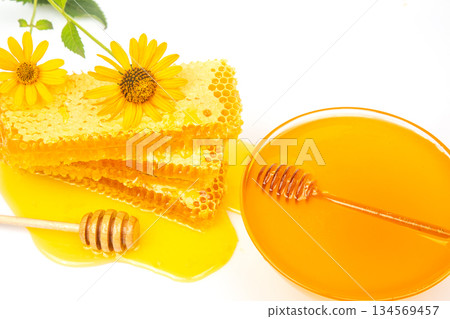 Fresh flower honey in combs and a wooden spoon. vitamin food for health and life Fresh flower honey in combs and a wooden spoon. vitamin food for health and life 134569457