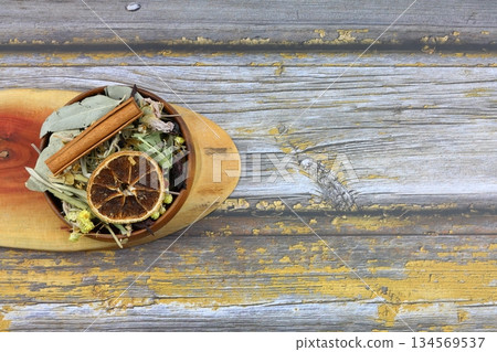 Winter tea for health in cold weather. Flavored with ginger, cinnamon, hibiscus, and orange. Isolated on woodenn background 134569537