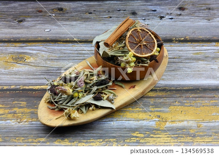 Winter tea for health in cold weather. Flavored with ginger, cinnamon, hibiscus, and orange. Isolated on woodenn background 134569538