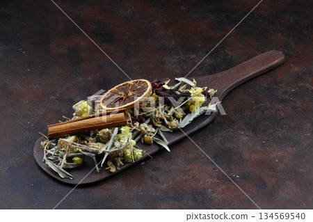 Winter tea for health in cold weather. Flavored with ginger, cinnamon, hibiscus, and orange. Isolated on woodenn background 134569540