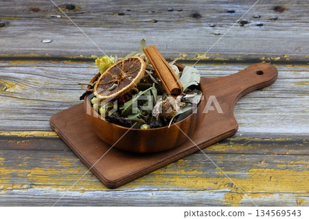 Winter tea for health in cold weather. Flavored with ginger, cinnamon, hibiscus, and orange. Isolated on woodenn background 134569543