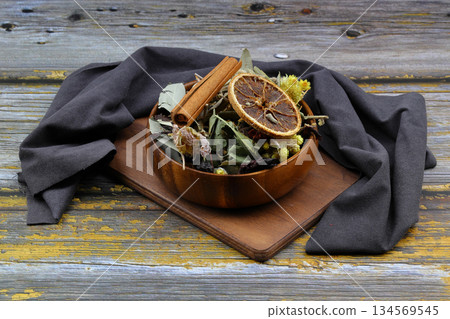 Winter tea for health in cold weather. Flavored with ginger, cinnamon, hibiscus, and orange. Isolated on woodenn background 134569545