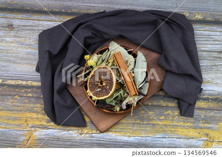 Winter tea for health in cold weather. Flavored with ginger, cinnamon, hibiscus, and orange. Isolated on woodenn background 134569546