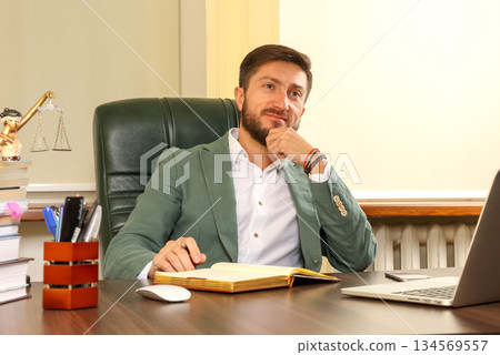 Professional man in a suit reflecting during a meeting in a modern office setting 134569557