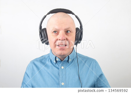 Person wearing headphones while listening to music indoors during daytime 134569592