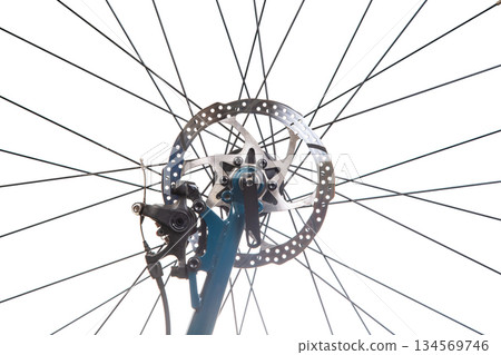 Close-up view of a bicycle wheel with spokes and brake components in bright light 134569746