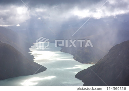 Natural beauty of Norway fjords with dramatic clouds and shimmering water reflections Natural beauty of Norway fjords with dramatic clouds and shimmering water reflections 134569836