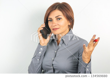 Business professional talking on phone while expressing concerns in a modern office setting 134569880