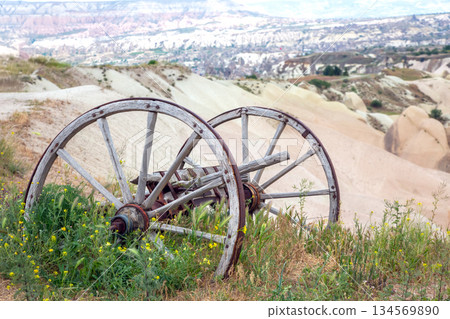 Old wooden wagon wheels resting on a hillside surrounded by natural beauty in Cappadocia 134569890