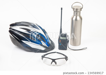 Essential gear for outdoor cycling adventures with helmet, sunglasses, radio, and water bottle 134569917