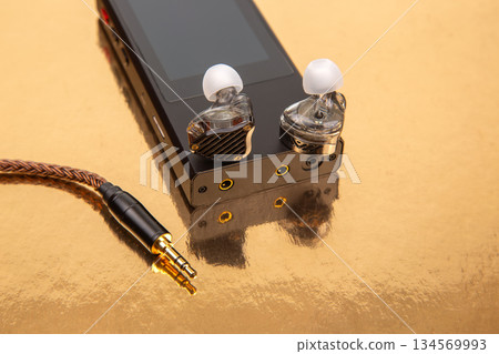 High-fidelity audio device with in-ear monitors on reflective surface 134569993