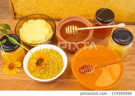 Variety of honey and bee products displayed on a wooden table with vibrant colors Variety of honey and bee products displayed on a wooden table with vibrant colors 134569996