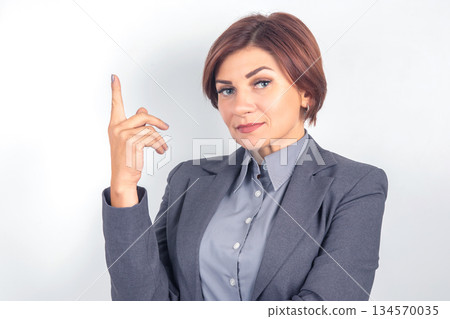 Business professional indicating a point with confidence in a studio setting Business professional indicating a point with confidence in a studio setting 134570035
