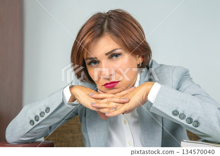 Professional woman thinking deeply during a meeting in a modern office environment 134570040