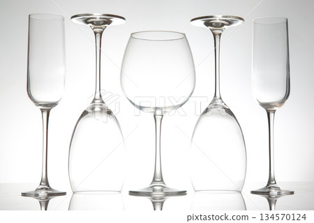 Elegant glassware arranged artistically against a white background with a soft glow 134570124
