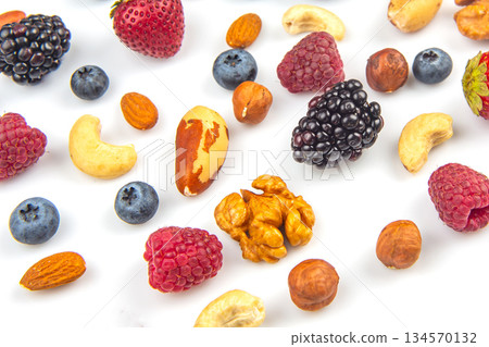 Colorful assortment of fresh fruits and nuts on a white background for healthy snacking 134570132