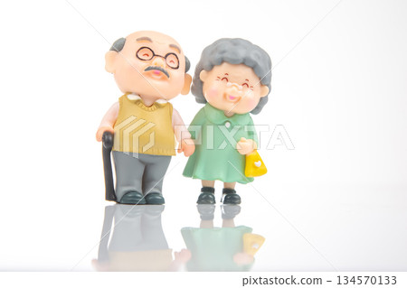 Miniature elderly couple walking together in a bright, cheerful environment Miniature elderly couple walking together in a bright, cheerful environment 134570133