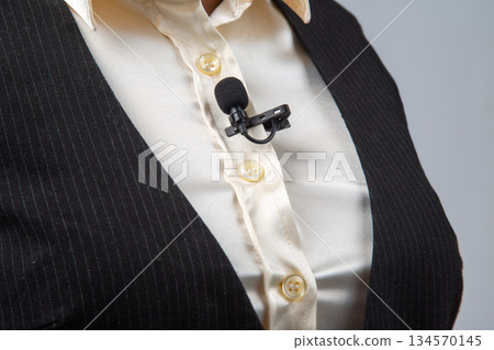 Professional speaker wearing a lapel microphone during an event in a conference setting 134570145