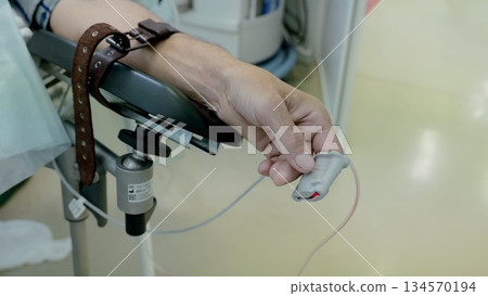 Patient checks in clinical setting, Postoperative patient under careful observation, Healthcare professionals closely observing patient vitals during recovery in sterile hospital environment Patient checks in clinical setting, Postoperative patient under careful observation, Healthcare professionals closely observing patient vitals during recovery in sterile hospital environment 134570194