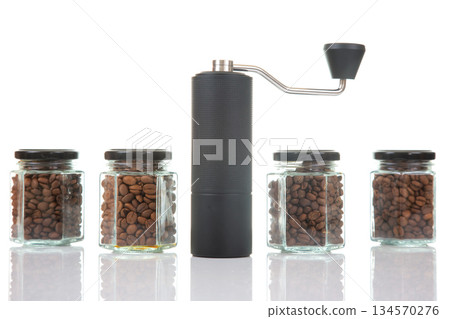Coffee grinder with glass jars of roasted beans displayed on a white background 134570276